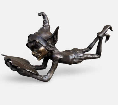 Bronze laying pixie reading