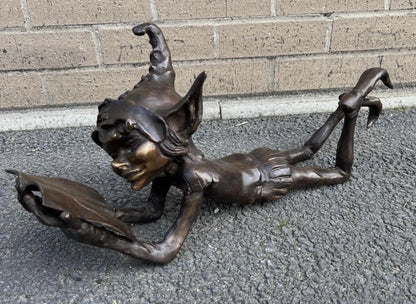 Bronze laying pixie reading