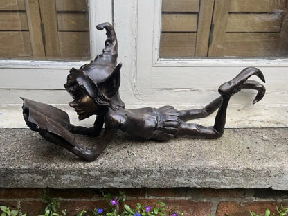 Bronze laying pixie reading