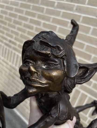Bronze laying pixie reading
