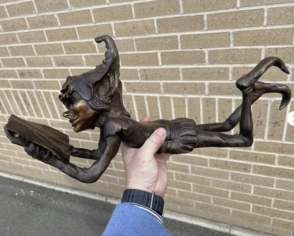 Bronze laying pixie reading